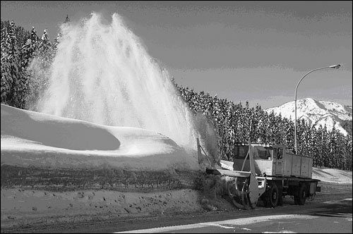 Snow blower clearing highway.